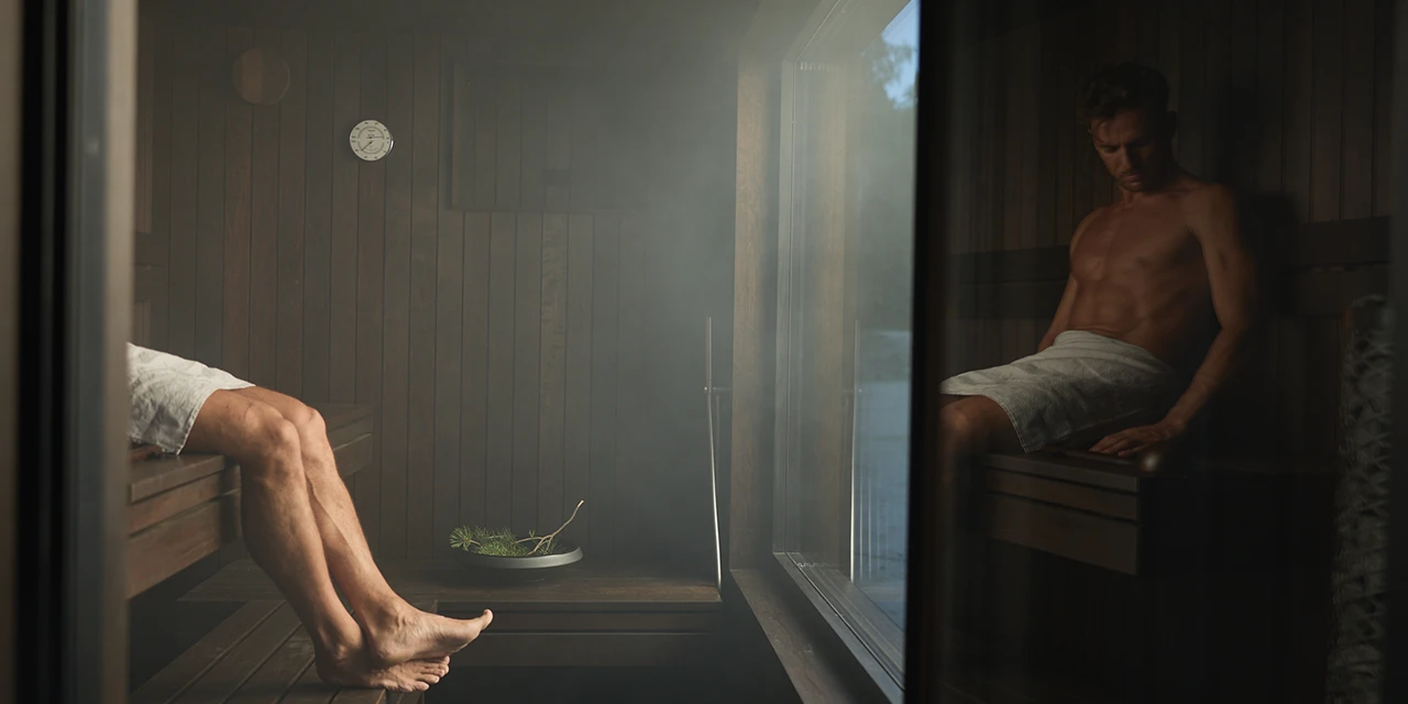 Two people relaxing in a steam-filled Steam Spirit sauna interior
